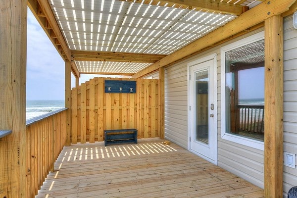 wooden deck featuring a pergola and a water view