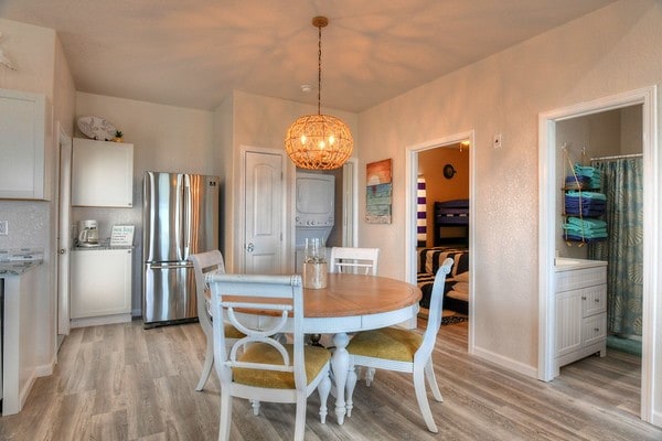 dining room with light hardwood / wood-style floors and an inviting chandelier