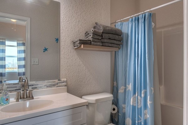 bathroom featuring curtained shower, vanity, and toilet