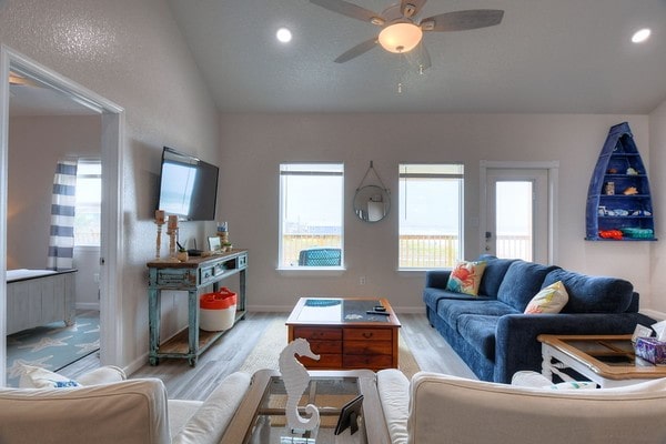 living room featuring a wealth of natural light, light hardwood / wood-style flooring, and ceiling fan