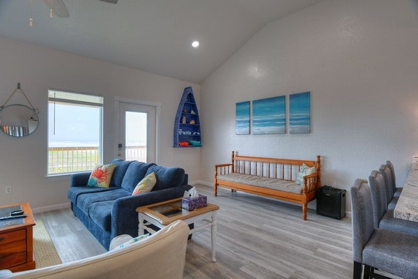 living room featuring ceiling fan, vaulted ceiling, and hardwood / wood-style flooring