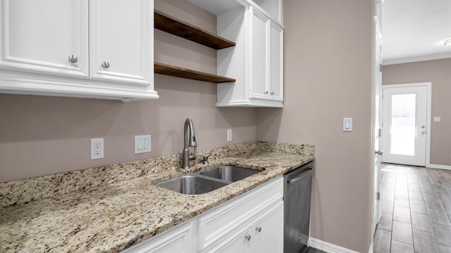 kitchen with light stone countertops, light wood-type flooring, sink, dishwasher, and white cabinetry