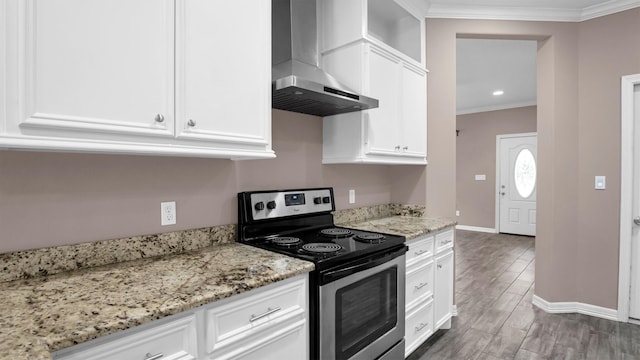 kitchen featuring electric range, light stone countertops, white cabinets, and wall chimney range hood