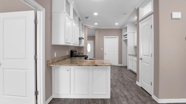 kitchen featuring white cabinets, dark hardwood / wood-style floors, light stone countertops, stainless steel range, and kitchen peninsula