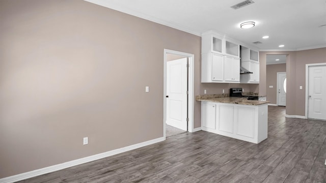 kitchen featuring light stone countertops, stainless steel range, white cabinets, and wood-type flooring