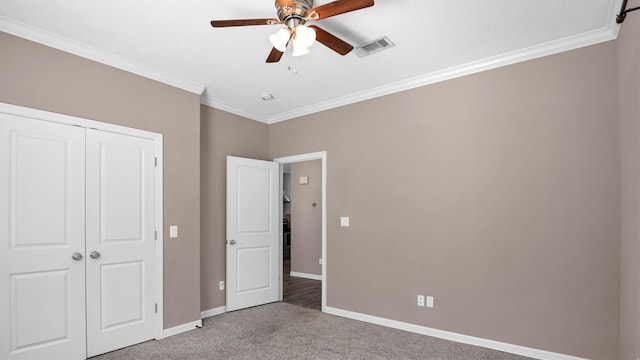 unfurnished bedroom with carpet flooring, a closet, ceiling fan, and crown molding