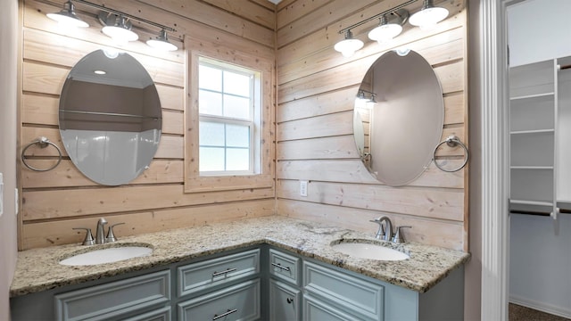 bathroom featuring vanity and wooden walls