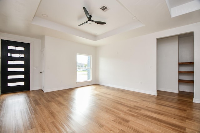 foyer featuring a tray ceiling, ceiling fan, and light hardwood / wood-style flooring