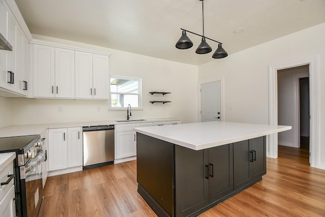 kitchen featuring white cabinets, stainless steel appliances, hanging light fixtures, and sink