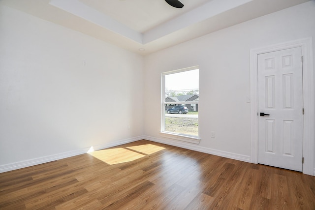 spare room featuring hardwood / wood-style floors and a tray ceiling