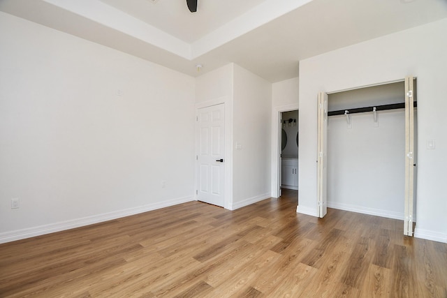 unfurnished bedroom with a closet, light hardwood / wood-style flooring, and ceiling fan