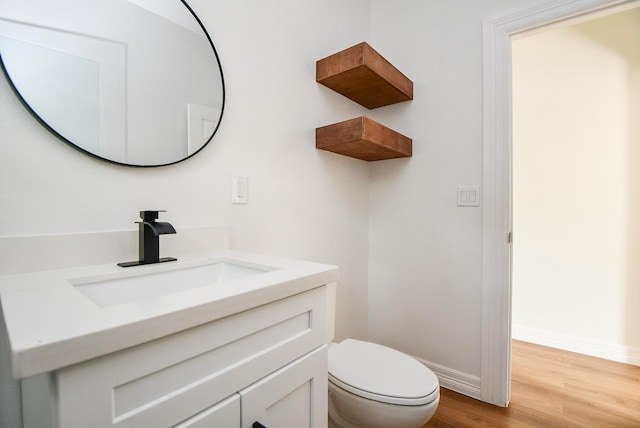 bathroom with wood-type flooring, vanity, and toilet