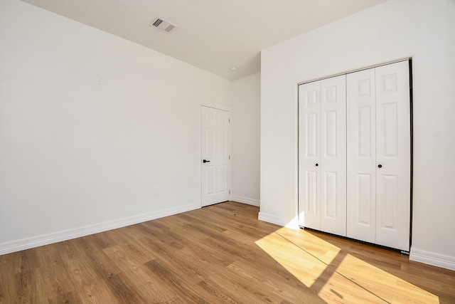 unfurnished bedroom with hardwood / wood-style flooring and a closet