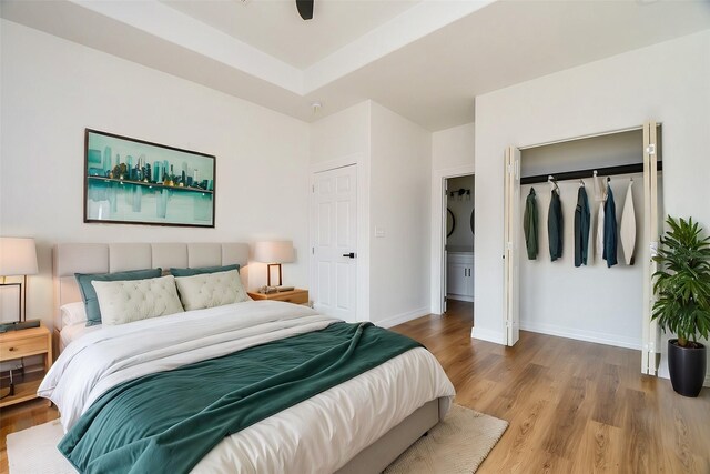 bedroom featuring hardwood / wood-style floors, ceiling fan, and a closet