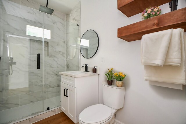 bathroom with hardwood / wood-style floors, vanity, toilet, and walk in shower