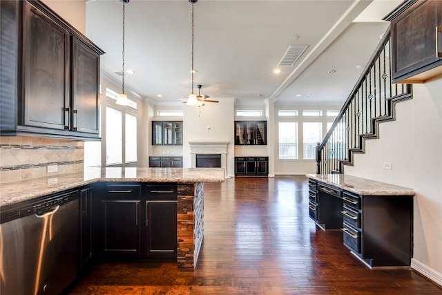 kitchen with dishwasher, light stone counters, dark hardwood / wood-style floors, pendant lighting, and dark brown cabinets