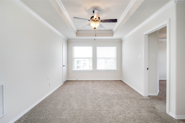 unfurnished room featuring a tray ceiling, crown molding, carpet flooring, and ceiling fan