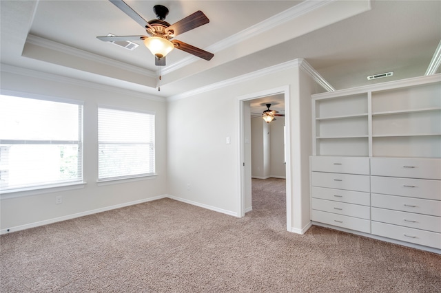 spare room featuring a tray ceiling, ceiling fan, crown molding, and light colored carpet