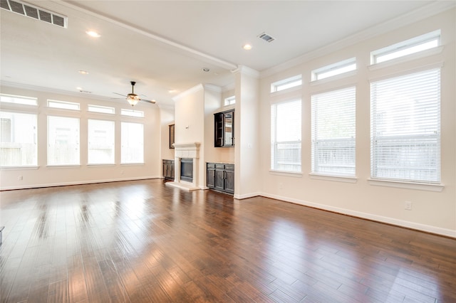 unfurnished living room featuring ceiling fan, dark hardwood / wood-style flooring, and ornamental molding