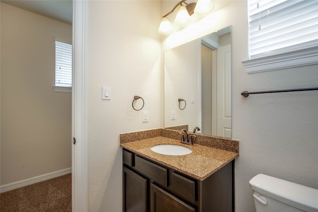 bathroom with vanity, toilet, and a wealth of natural light