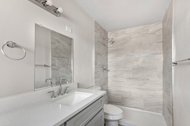 bathroom with vanity, toilet, and a tile shower