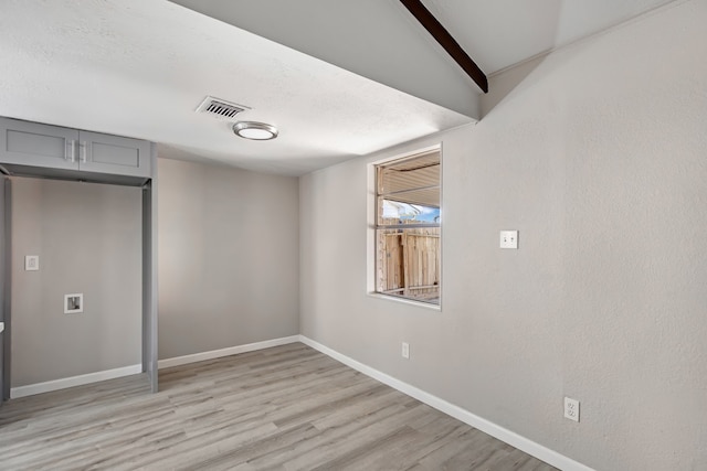 unfurnished bedroom with light wood-type flooring and lofted ceiling