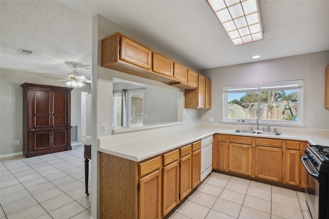 kitchen featuring gas range oven, white dishwasher, ceiling fan, sink, and light tile patterned flooring