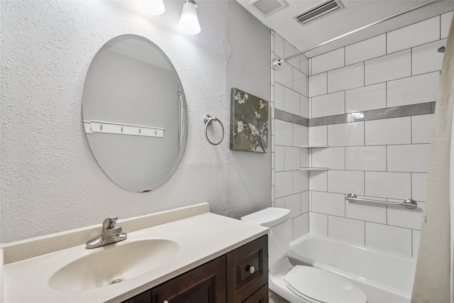 full bathroom featuring tiled shower / bath combo, toilet, a textured ceiling, and vanity