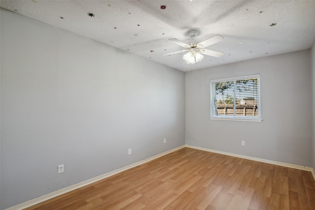 empty room with ceiling fan, light hardwood / wood-style floors, and a textured ceiling