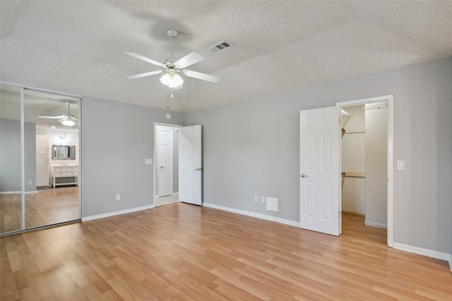 unfurnished bedroom featuring a textured ceiling, light hardwood / wood-style flooring, and ceiling fan