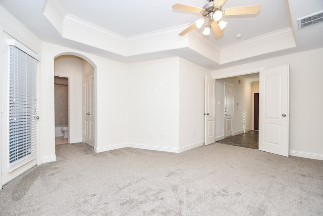 carpeted empty room featuring ceiling fan, crown molding, and a tray ceiling