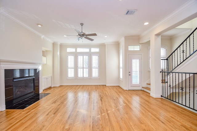 unfurnished living room featuring light wood-type flooring, crown molding, and a wealth of natural light