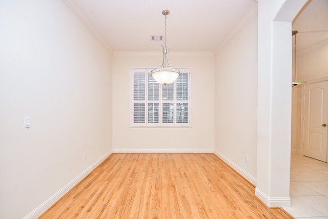 unfurnished room with light wood-type flooring and crown molding