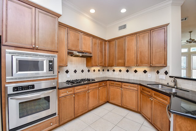 kitchen featuring ceiling fan, sink, appliances with stainless steel finishes, light tile patterned floors, and ornamental molding