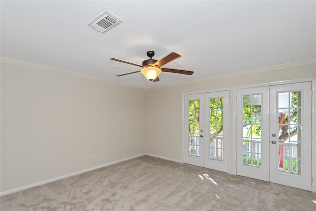 empty room with light carpet, french doors, and crown molding