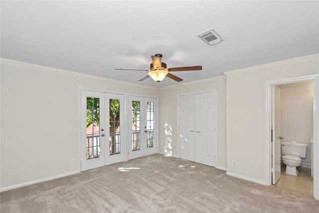 unfurnished bedroom with light carpet, french doors, access to exterior, ensuite bathroom, and ceiling fan