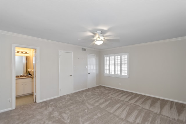 unfurnished bedroom with ceiling fan, light colored carpet, crown molding, and connected bathroom