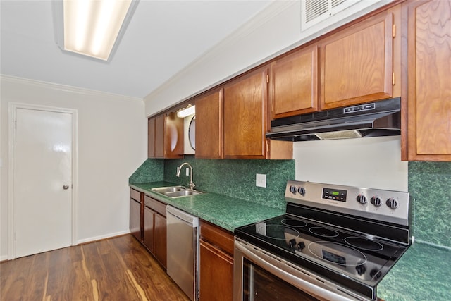 kitchen with backsplash, dark wood-type flooring, sink, ornamental molding, and appliances with stainless steel finishes