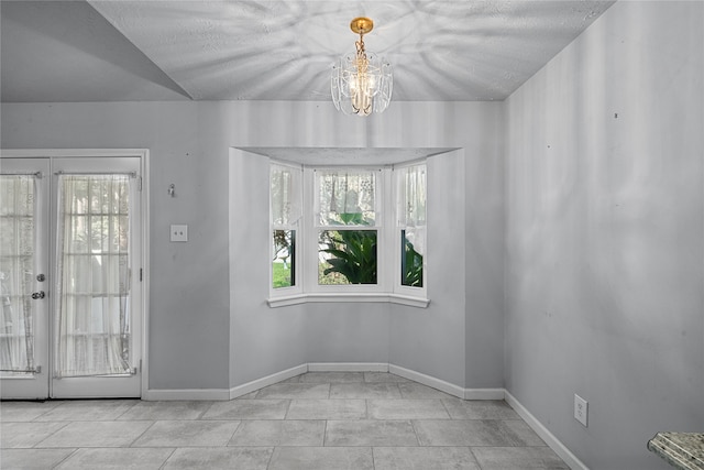 unfurnished dining area with french doors, a notable chandelier, and light tile patterned flooring