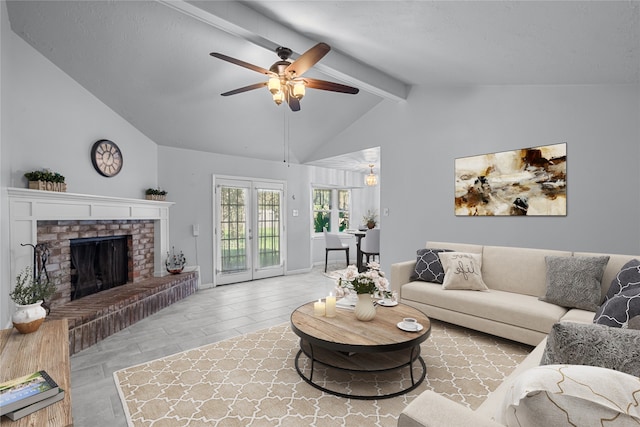 living room featuring vaulted ceiling with beams, light hardwood / wood-style floors, a fireplace, and ceiling fan