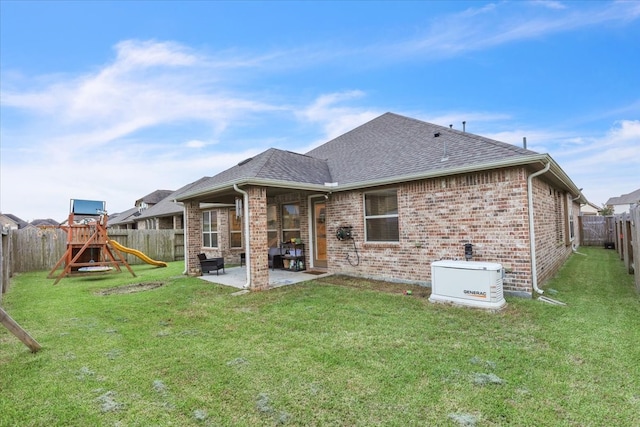 rear view of property with a yard, a patio, and a playground