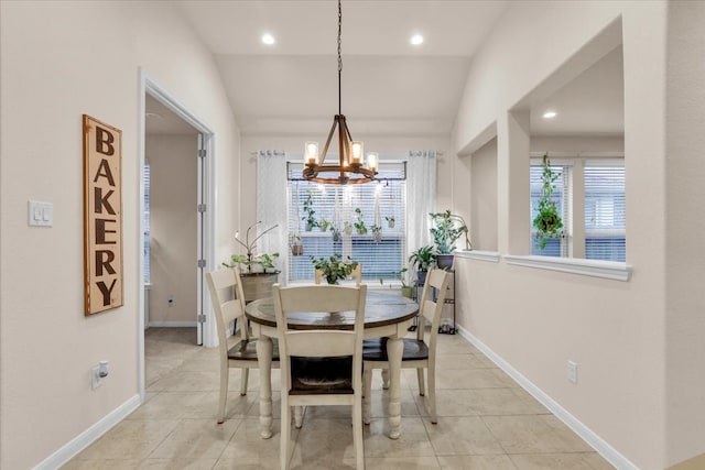 tiled dining room with a chandelier and lofted ceiling