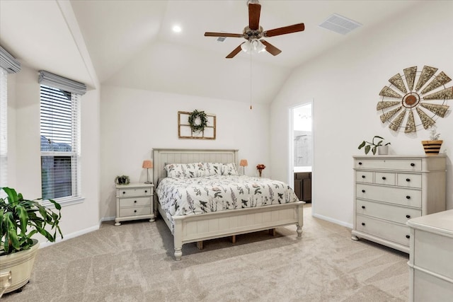 bedroom featuring ceiling fan, light colored carpet, connected bathroom, and vaulted ceiling