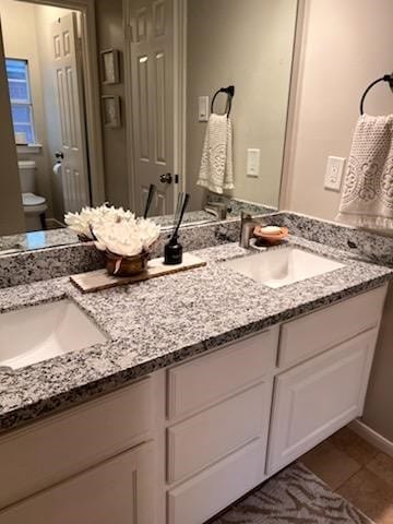 bathroom featuring tile patterned floors, vanity, and toilet