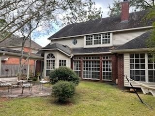 back of house with a lawn and a patio area