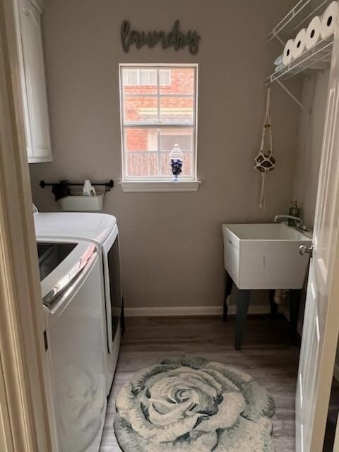 laundry room featuring hardwood / wood-style floors, sink, and washing machine and clothes dryer