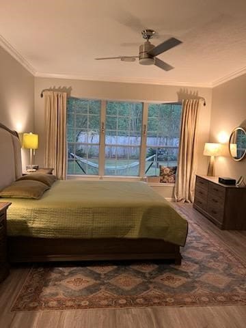 bedroom featuring ceiling fan, dark hardwood / wood-style floors, and ornamental molding