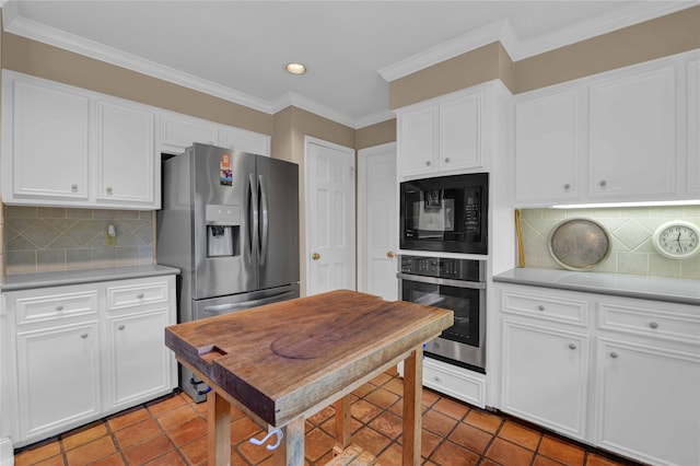 kitchen with backsplash, white cabinets, crown molding, light tile patterned flooring, and stainless steel appliances