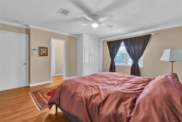 bedroom featuring ceiling fan, crown molding, and light hardwood / wood-style floors