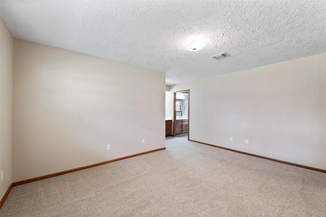 carpeted empty room with a textured ceiling